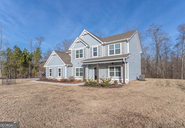 view of front of home featuring board and batten siding, cooling unit, and a front yard