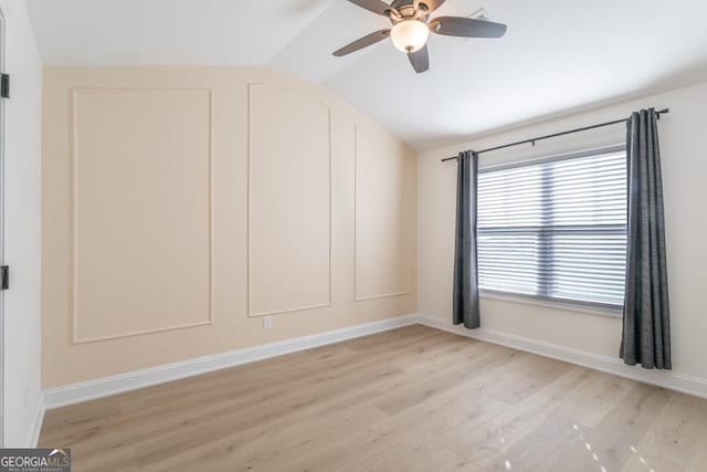 unfurnished room featuring lofted ceiling, light wood-style flooring, baseboards, and a ceiling fan