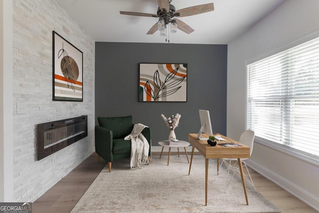 office with a fireplace, plenty of natural light, and wood finished floors