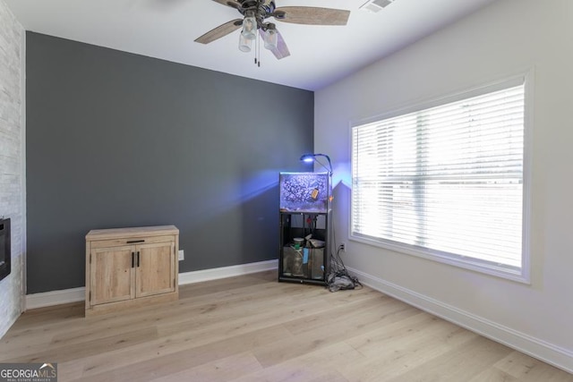 misc room featuring light wood-style floors, visible vents, baseboards, and a ceiling fan