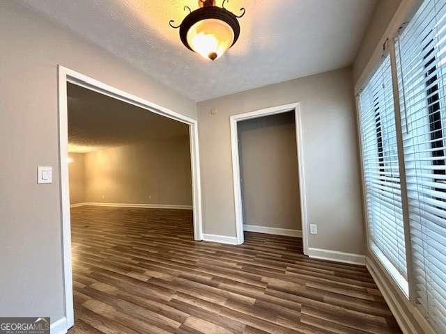 unfurnished bedroom featuring dark hardwood / wood-style floors and a closet