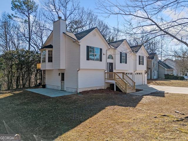 view of front facade with a garage, a front lawn, and a patio