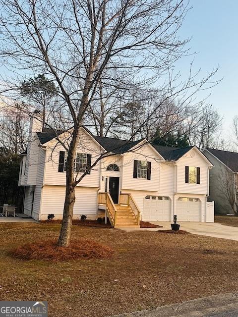 view of front of house featuring a garage, a patio, and a front yard