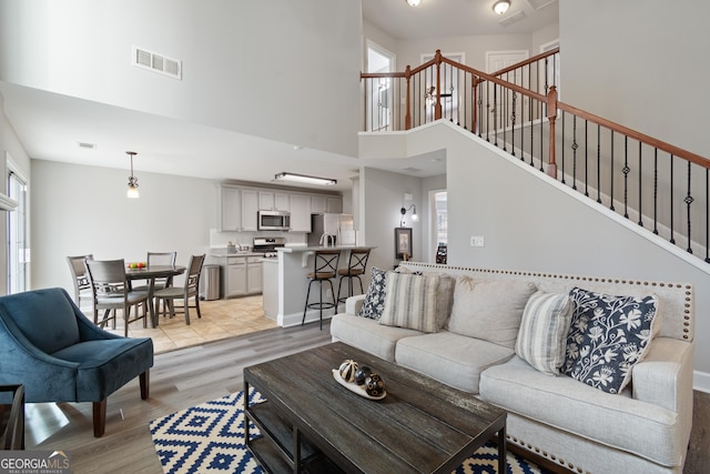 living room featuring a high ceiling and light hardwood / wood-style floors