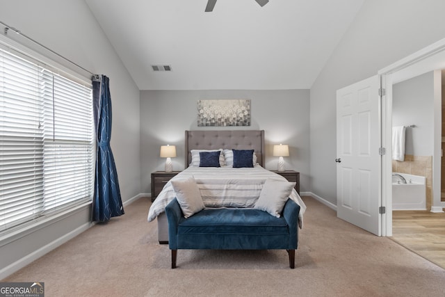 carpeted bedroom featuring connected bathroom, vaulted ceiling, and ceiling fan