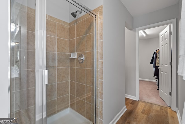 bathroom with walk in shower and wood-type flooring