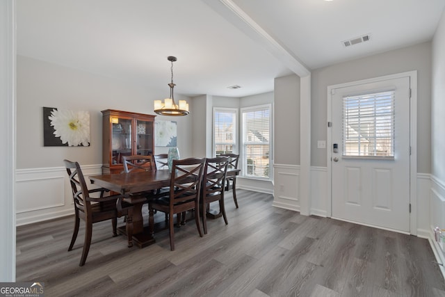 dining area featuring dark wood-type flooring and an inviting chandelier