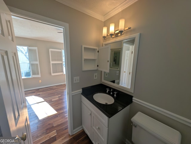 bathroom featuring crown molding, hardwood / wood-style floors, vanity, a textured ceiling, and toilet