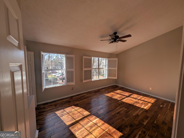 spare room featuring ceiling fan, dark hardwood / wood-style flooring, and a textured ceiling