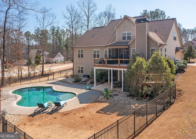 view of swimming pool featuring a sunroom, a patio area, a fenced in pool, and a fenced backyard