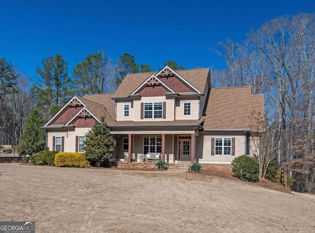 craftsman-style home featuring covered porch and a shingled roof