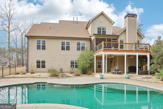 rear view of house featuring a fenced in pool, fence, a sunroom, a patio area, and a ceiling fan