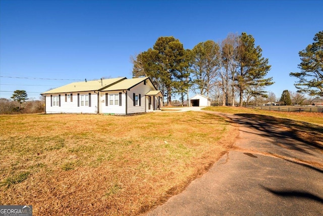 exterior space featuring an outbuilding, a garage, and a front yard