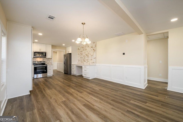 kitchen with appliances with stainless steel finishes, dark hardwood / wood-style floors, decorative light fixtures, white cabinetry, and backsplash