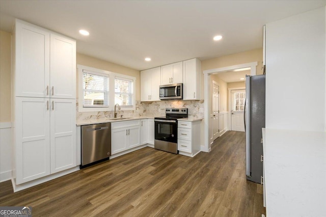 kitchen featuring stainless steel appliances, tasteful backsplash, sink, and white cabinets