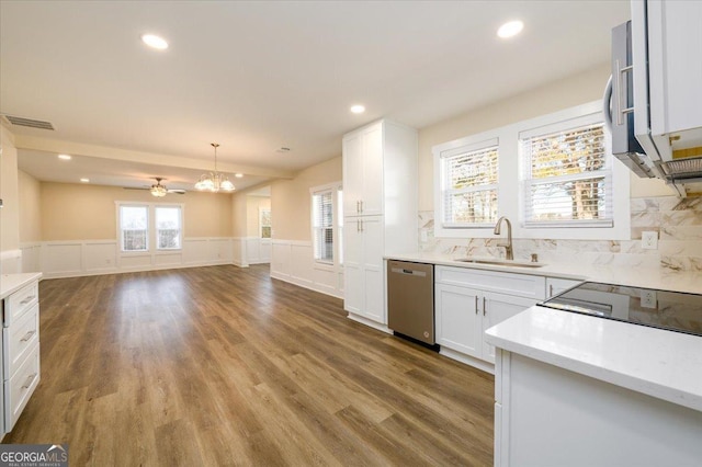 kitchen featuring sink, dishwasher, white cabinetry, tasteful backsplash, and decorative light fixtures