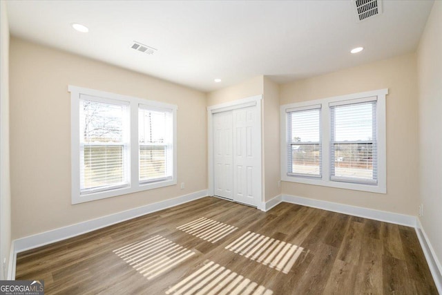 unfurnished bedroom with dark hardwood / wood-style flooring and a closet