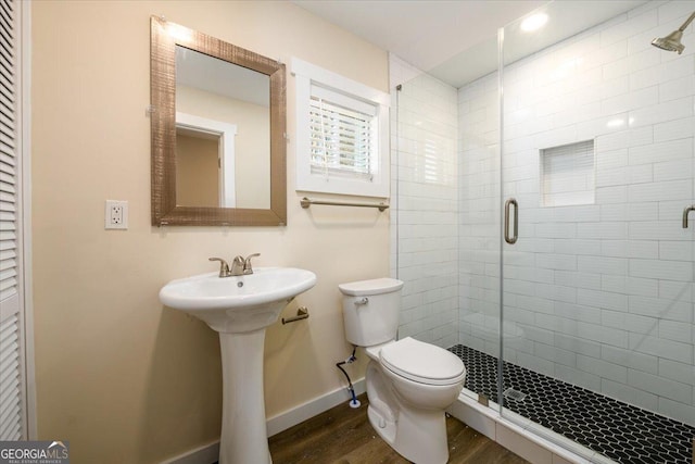 bathroom with sink, toilet, an enclosed shower, and hardwood / wood-style floors