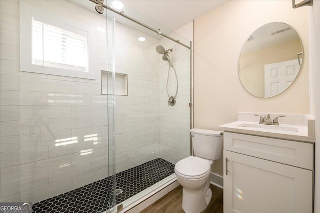 bathroom with vanity, a shower with shower door, and toilet