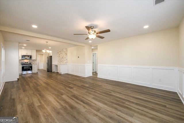 unfurnished living room with dark hardwood / wood-style flooring and ceiling fan with notable chandelier