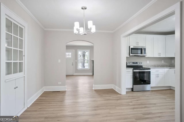 kitchen featuring stainless steel appliances, white cabinetry, pendant lighting, and a notable chandelier