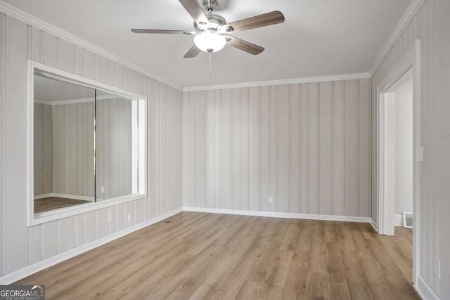 empty room with ornamental molding, ceiling fan, and light wood-type flooring