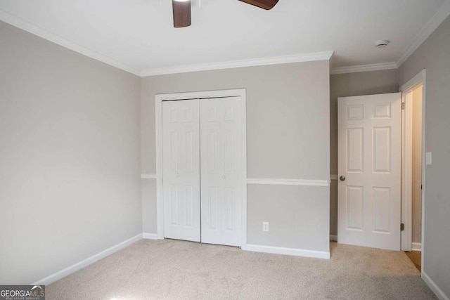 unfurnished bedroom with crown molding, light colored carpet, a closet, and ceiling fan