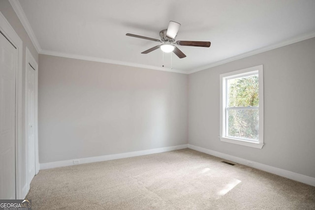 unfurnished room featuring ornamental molding, carpet, and ceiling fan