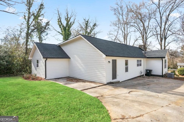 view of property exterior with a yard and central air condition unit