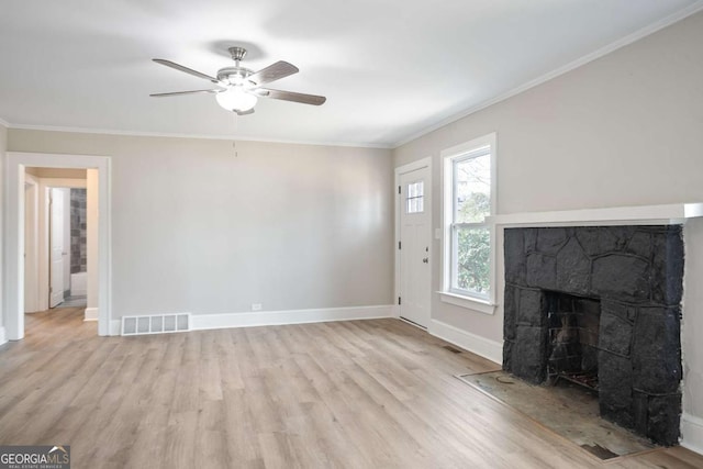 unfurnished living room featuring ceiling fan, ornamental molding, a stone fireplace, and light hardwood / wood-style floors