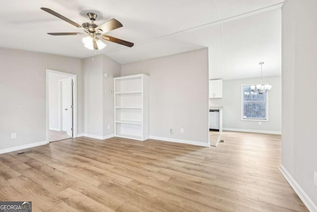 spare room with lofted ceiling, ceiling fan with notable chandelier, and light wood-type flooring