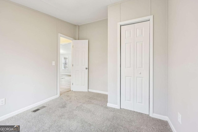 unfurnished bedroom with carpet and a closet