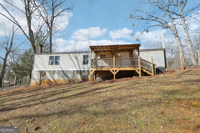 rear view of house with a deck and a lawn