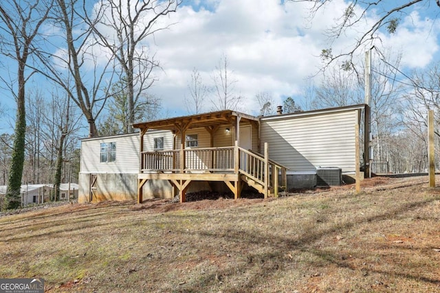 rear view of property featuring a yard, central air condition unit, and a deck