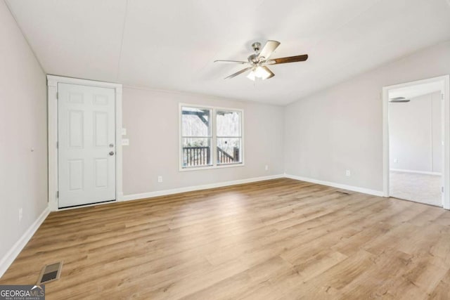 empty room with vaulted ceiling, ceiling fan, and light wood-type flooring