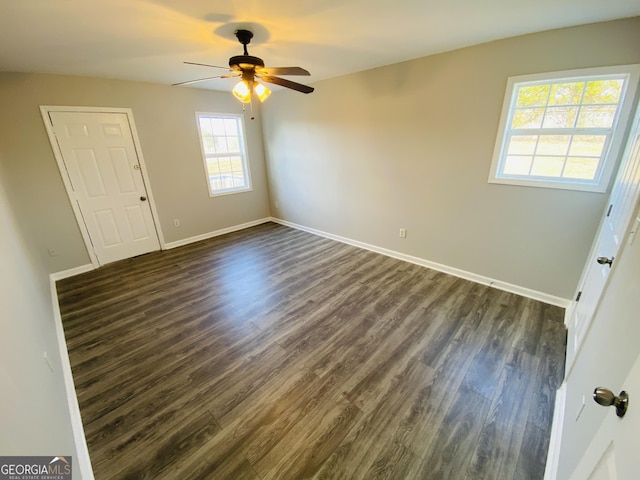 empty room featuring dark wood-type flooring and ceiling fan