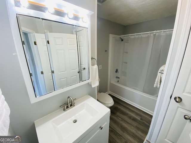 full bathroom with toilet, a textured ceiling, hardwood / wood-style flooring, vanity, and shower / bath combination with curtain