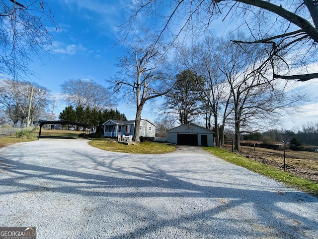 view of front facade featuring a carport, a garage, an outdoor structure, and a front lawn