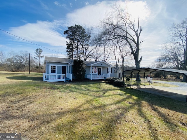 view of front facade with an outdoor structure, a front lawn, a carport, and a porch