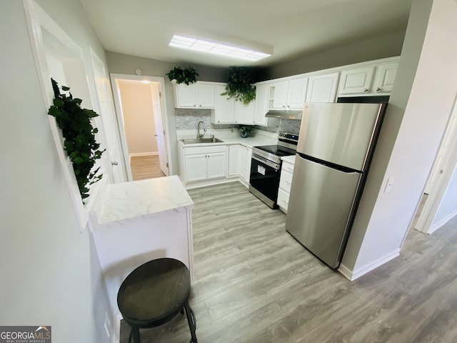 kitchen featuring sink, backsplash, white cabinets, and appliances with stainless steel finishes