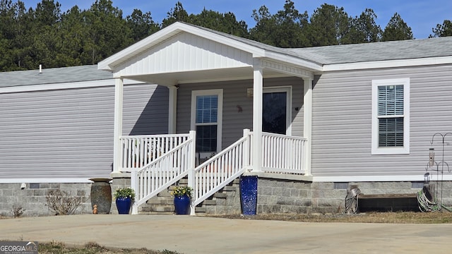 property entrance with crawl space, covered porch, and a shingled roof