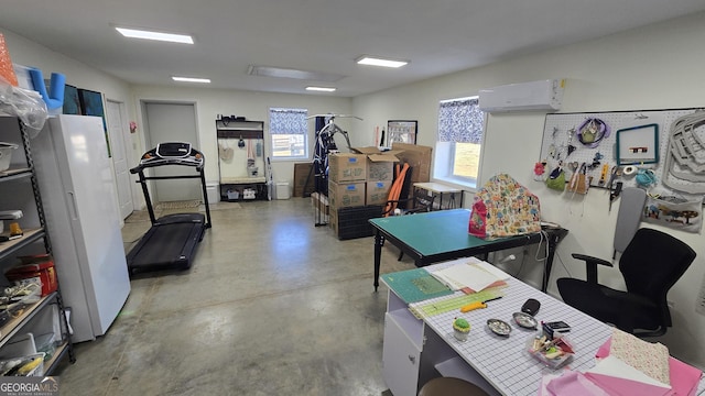 home office featuring a wall mounted air conditioner, a wealth of natural light, and concrete flooring