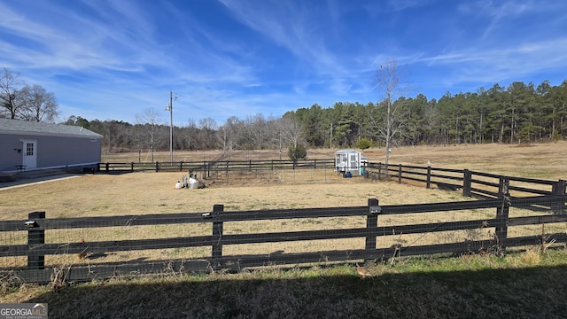 view of yard with a forest view, a rural view, and fence