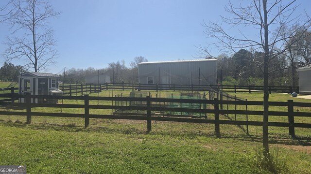 view of yard featuring a rural view and a storage unit