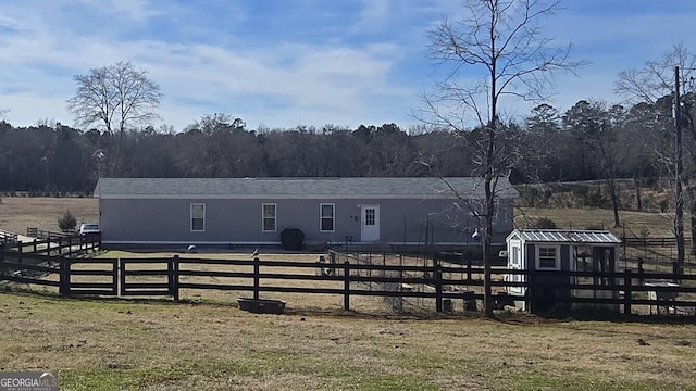 view of stable featuring a rural view and a view of trees