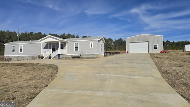 manufactured / mobile home featuring a garage, an outdoor structure, a porch, and a front lawn