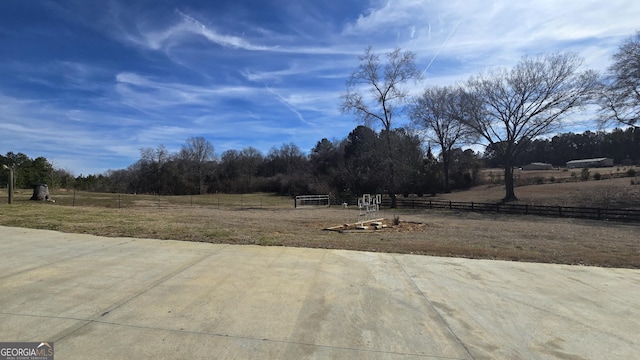 view of yard with a rural view and fence