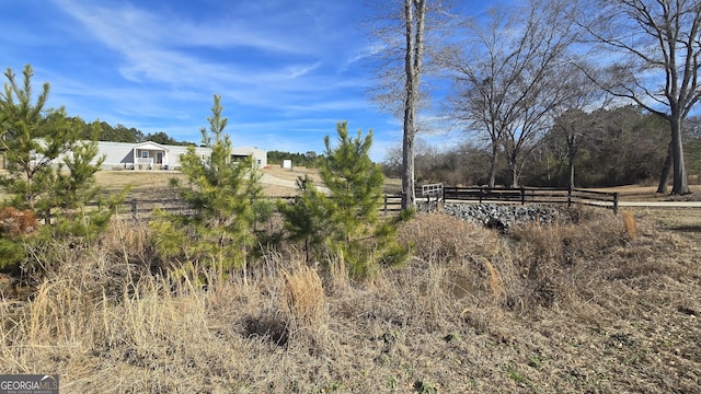 view of yard featuring a rural view and fence