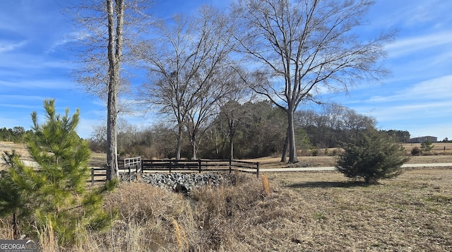 view of yard with a rural view and fence