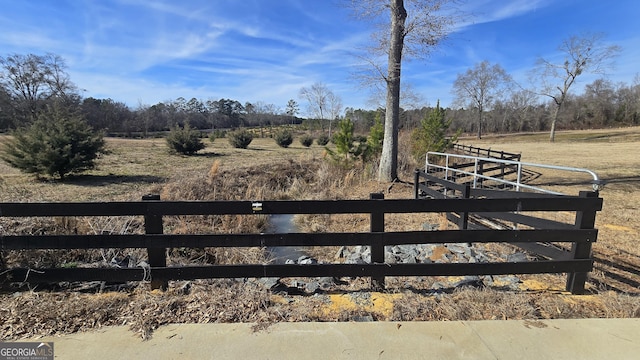 view of yard featuring a rural view and fence